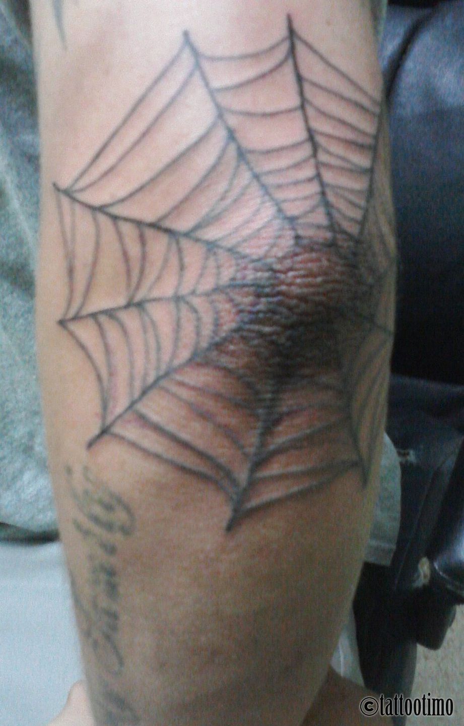 web on elbow tattoo