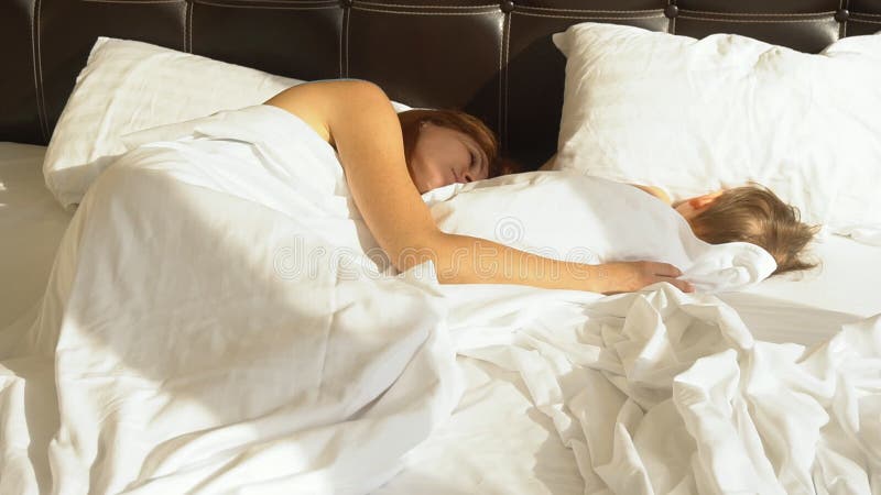 mom and son share hotel bed